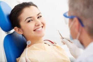 'woman getting teeth cleaned'